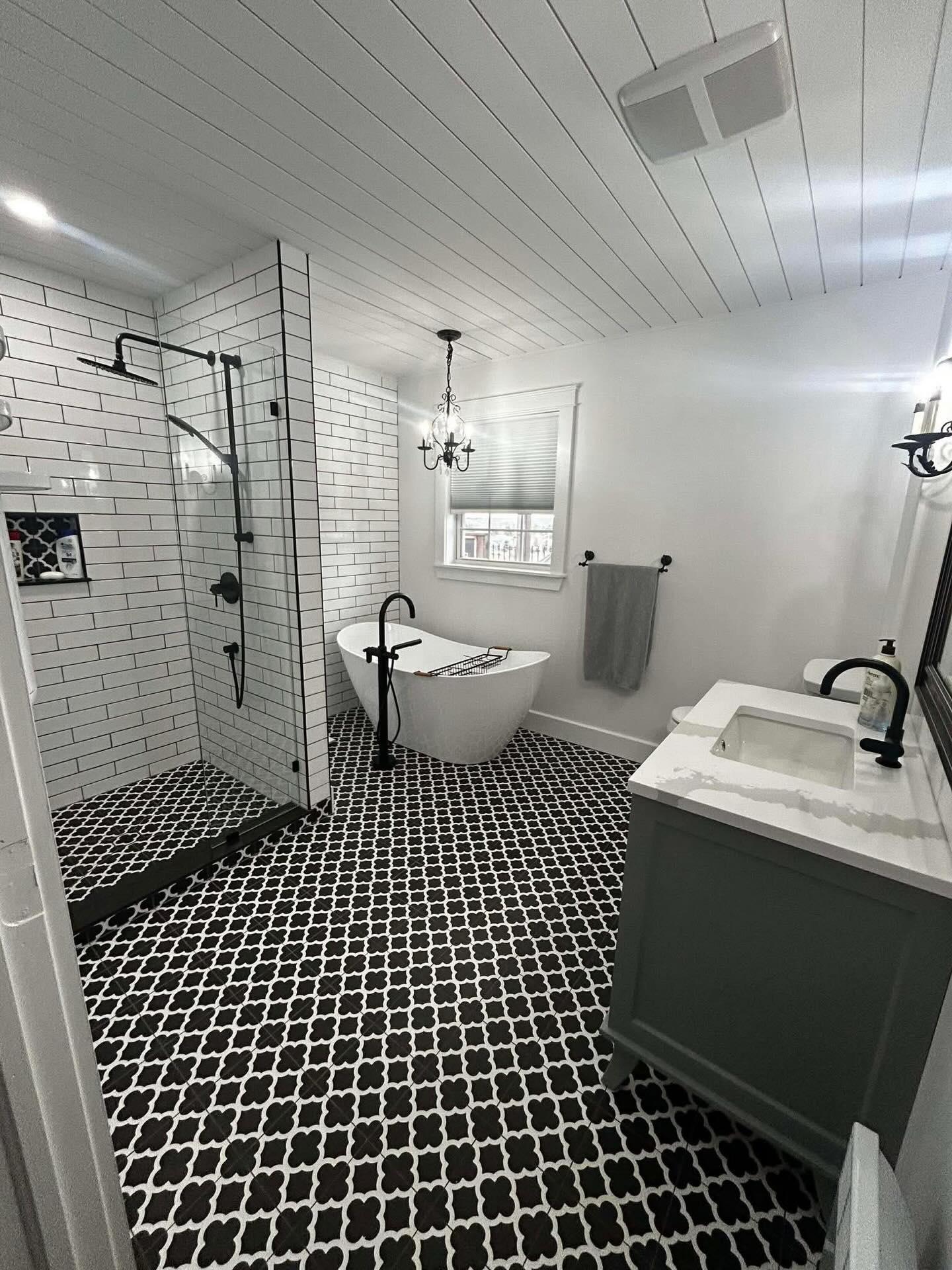 Custom tiled bathroom with subway tile shower and patterned floor