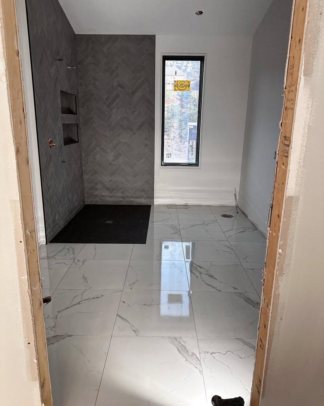 Marble-look large-format floor tile with herringbone shower wall
